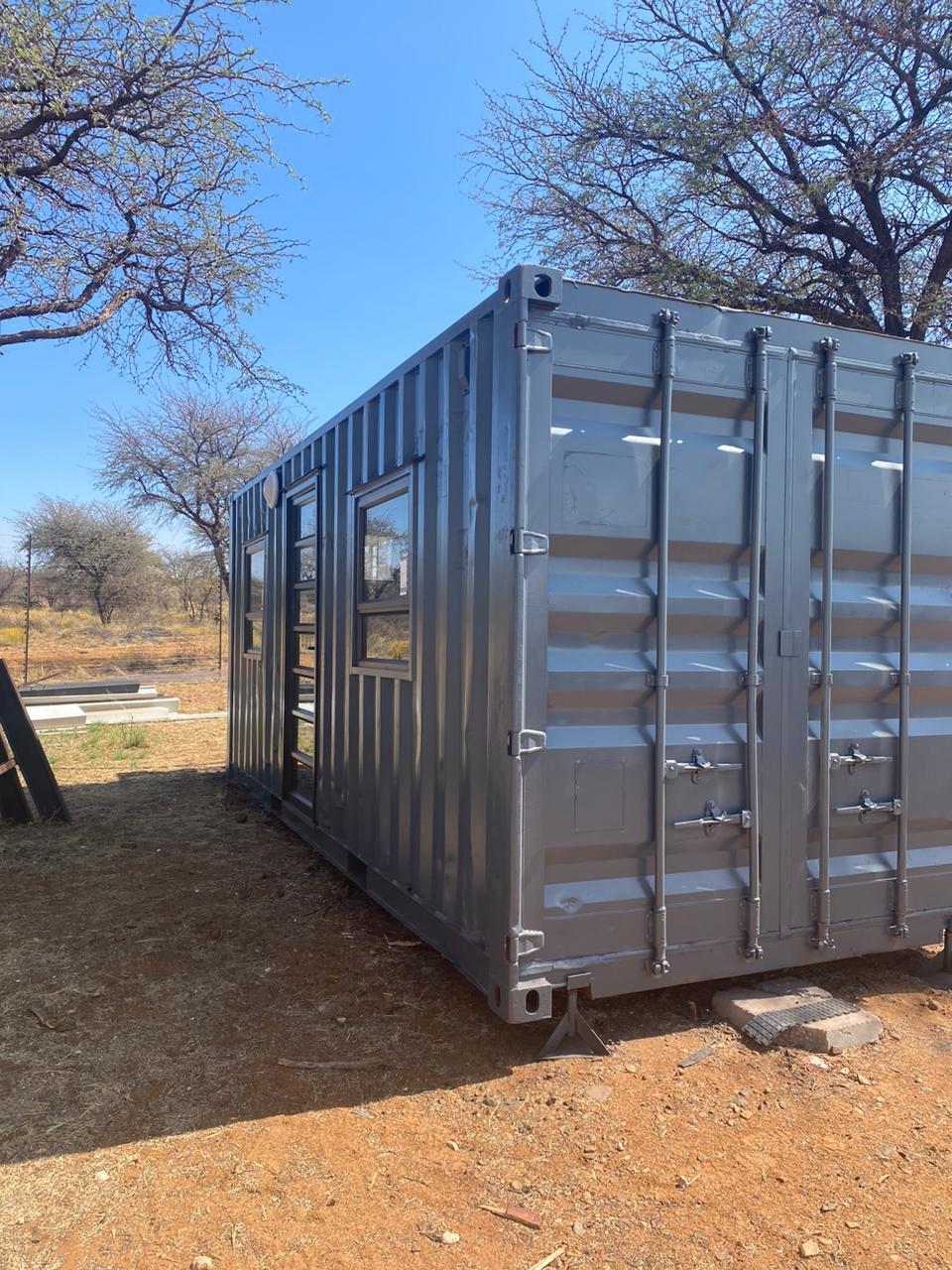 Logistical site delivery of a container cabin being offloaded from a truck crane